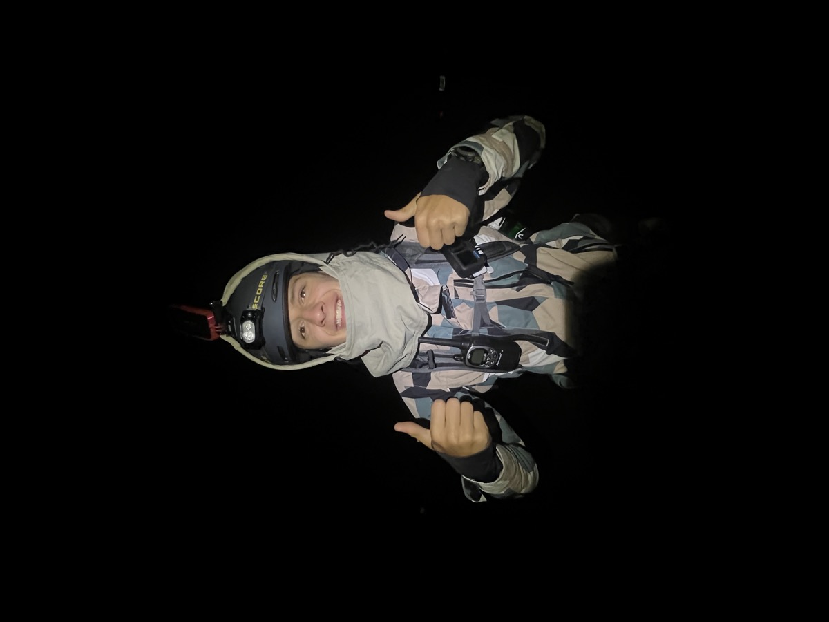 Jude in a helmet and headlamp at night, thumbs up