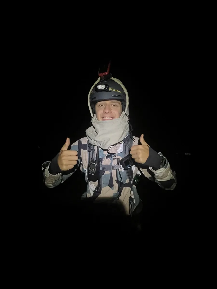 Jude in a helmet and headlamp at night, thumbs up